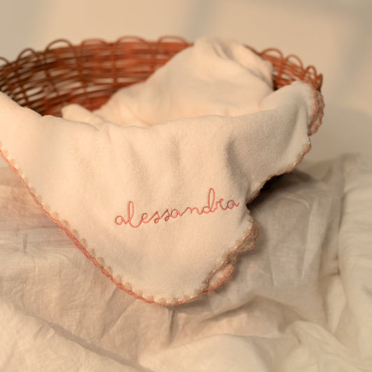 Detalle de cobija Caricia Polar para bebé con bordado en rosa