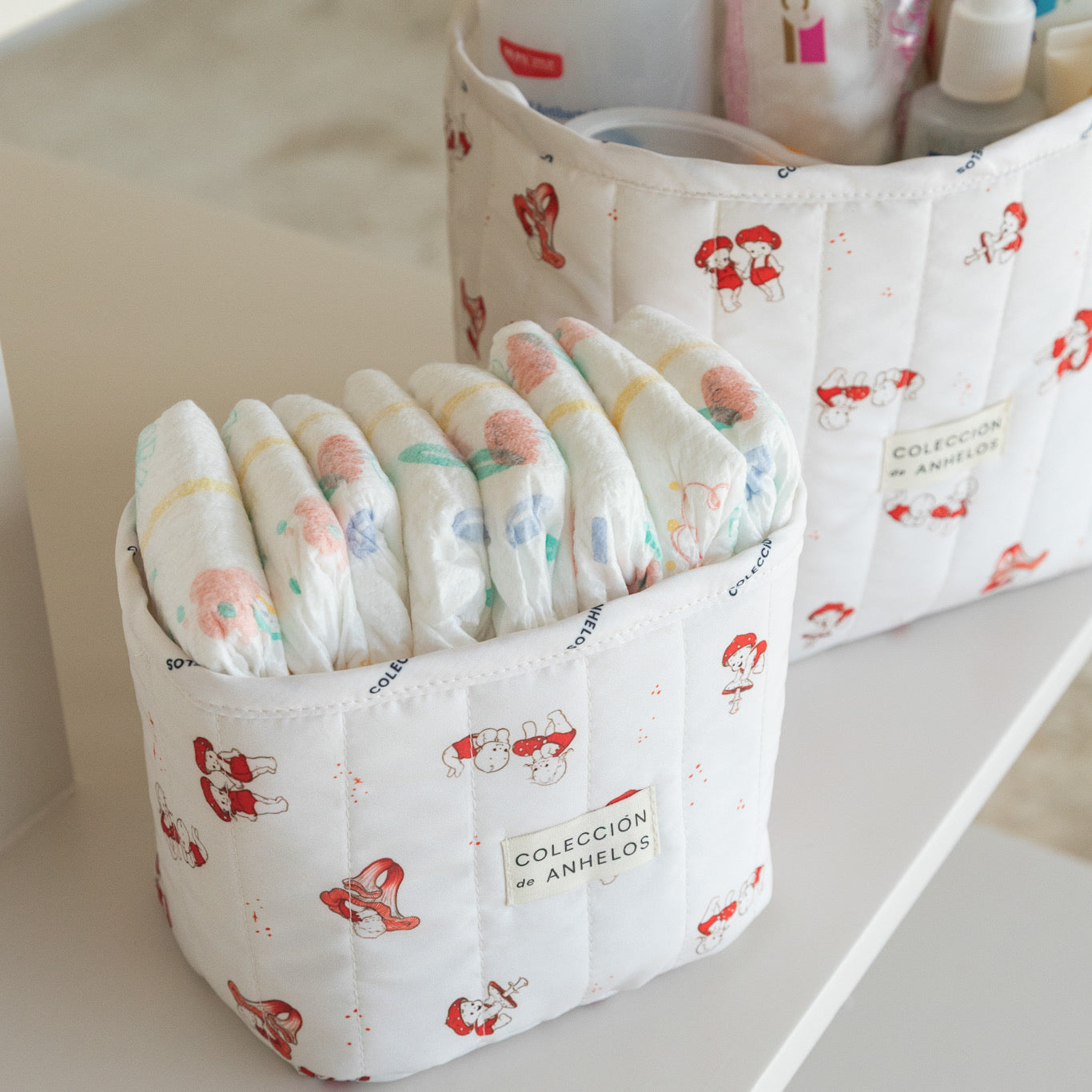     Detalle de organizador de cambiador para bebé con estampado en tono marfil y artículos de cuidado