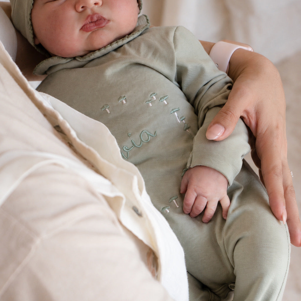 Bebé de tres meses con mameluco de algodón en color verde personalizado en uso