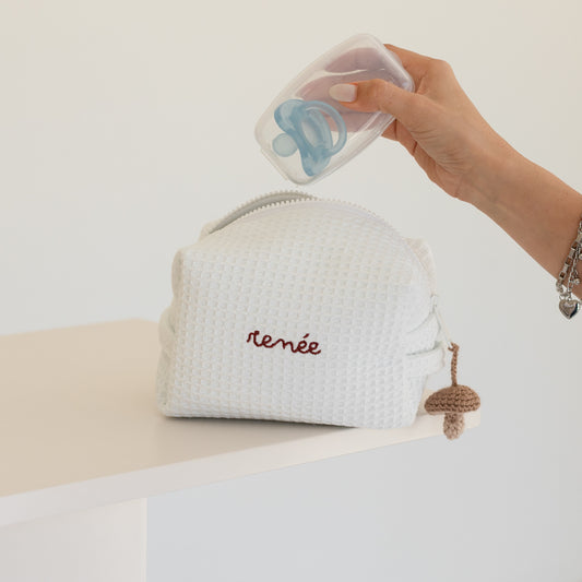 Neceser para bebé personalizado con bordado color ladrillo con mano guardando chupón