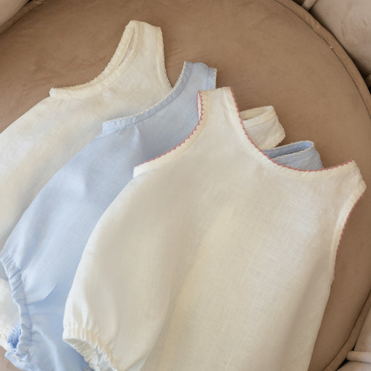 Pañaleros de lino para bebé en diferentes combinaciones de color y bordado sobre sillón