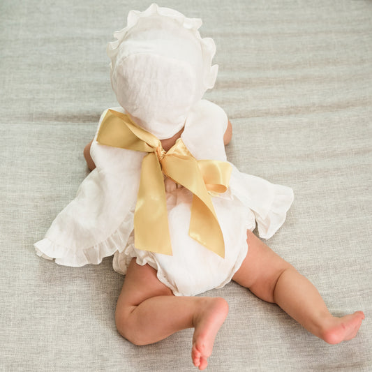 Bebé con vestido de lino para bebé celebración con cubrepañal en vista trasera